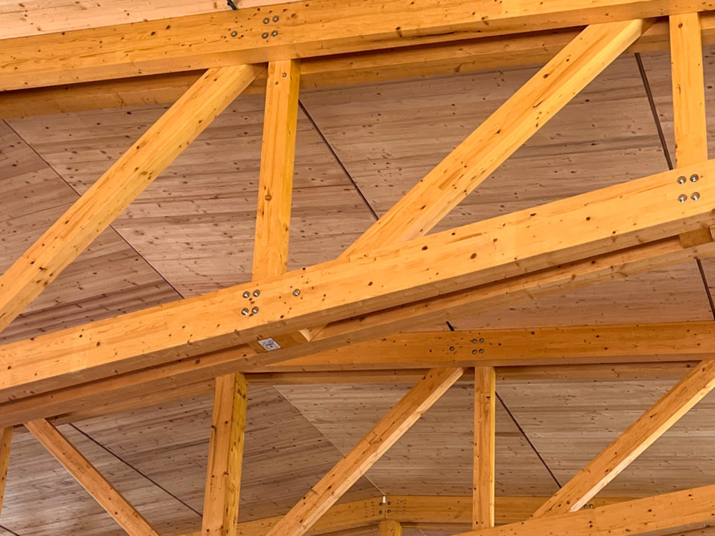 Photo intérieur de la toiture de la halle sportive de Génelard. On aperçoit notre finition d'atelier en volige qui restera brute.