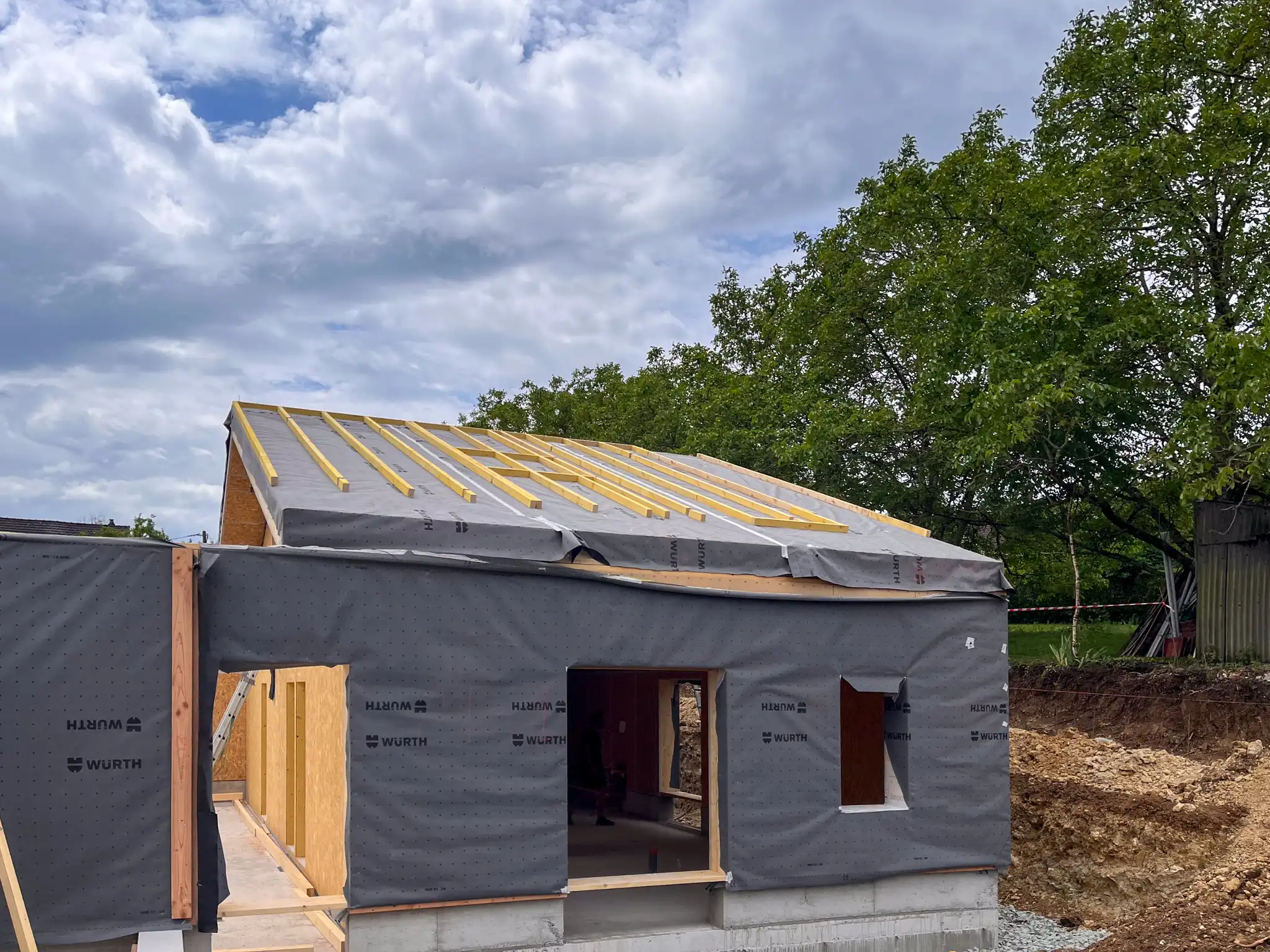 Vue extérieure de la première partie du chantier posé. Le tout est recouvert de pare-pluie pour protéger les caissons en attendant la pose d'un revêtement extérieur.