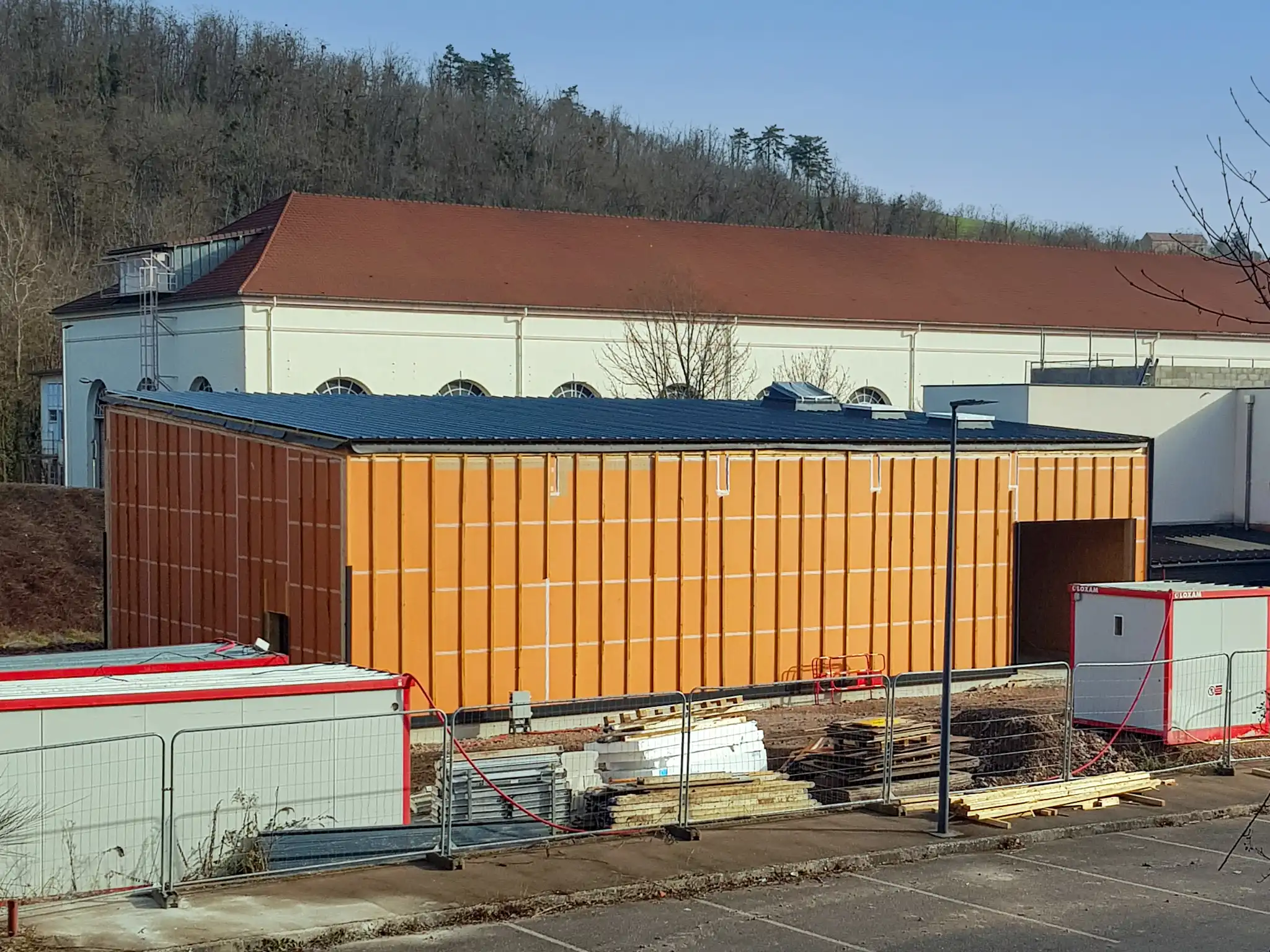 Le bâtiment est visible dans son entièreté, on peut encore différencier les caissons. C'est un grand espace de stockage industriel. La toiture est recouverte d'un bac acier ondulé.