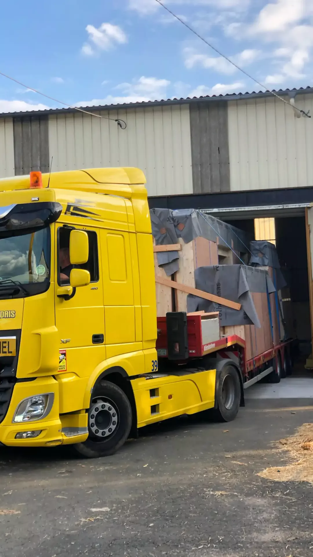 Départ d’un camion chargé de caissons de murs Un poids lourd sort de notre atelier à Blanzy avec nos caissons préfabriqués comme chargement. Il part en direction du chantier.
